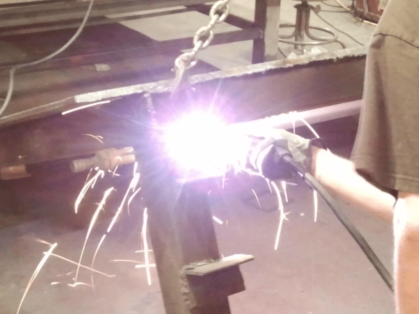 A person is welding in the middle of a room.