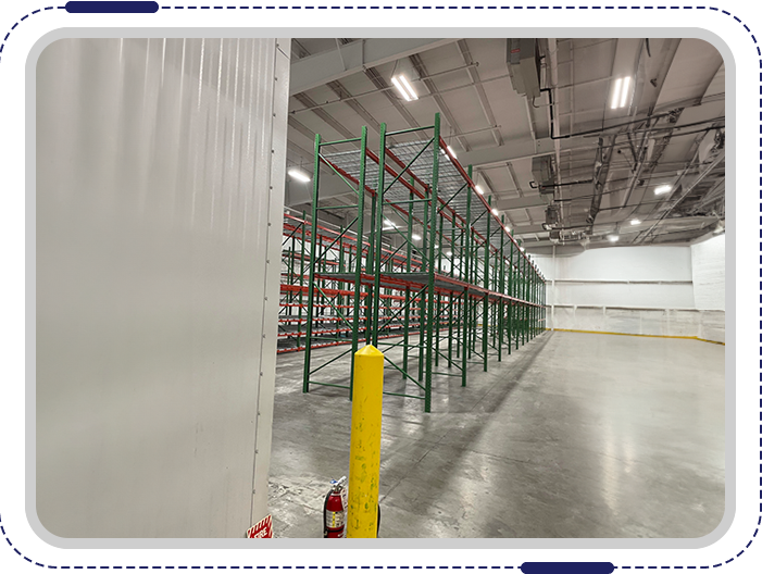 A warehouse with many rows of shelves and a yellow pole.