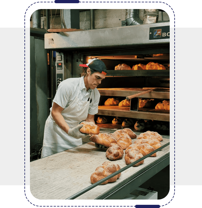 A baker in front of an oven with some pastries.